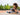 Woman using a foam roller outdoors with trees in the background